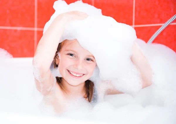 Menina bonito feliz está tomando um banho — Fotografia de Stock