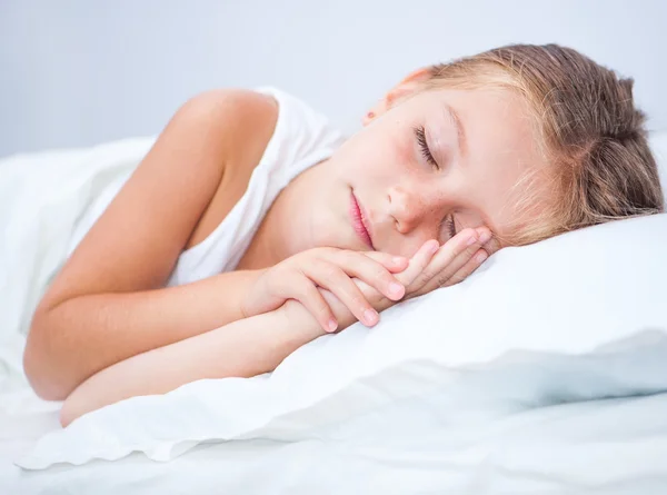 Mädchen schläft im weißen Bett — Stockfoto