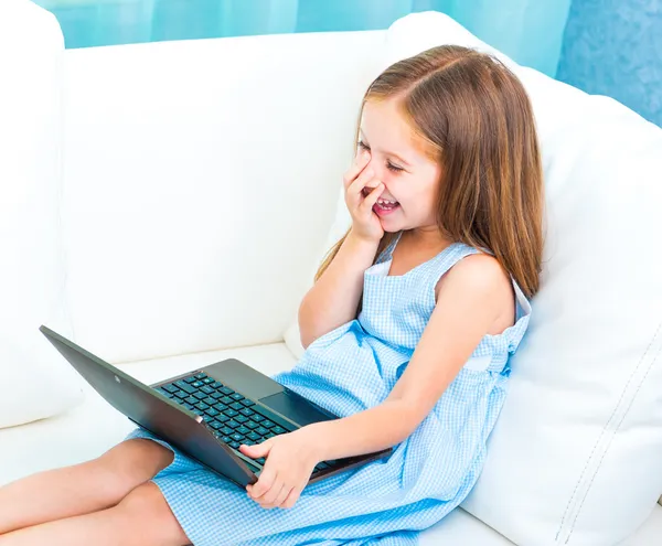 Lilla söta tjejen med en bärbar dator — Stockfoto