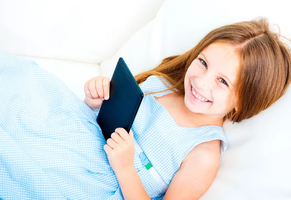 Niña sosteniendo un libro electrónico —  Fotos de Stock