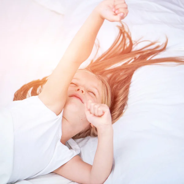 Girl lying in white bed — Stock Photo, Image