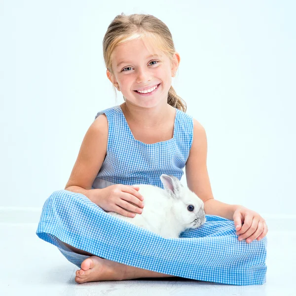 Sevimli küçük kız beyaz bir tavşan — Stok fotoğraf