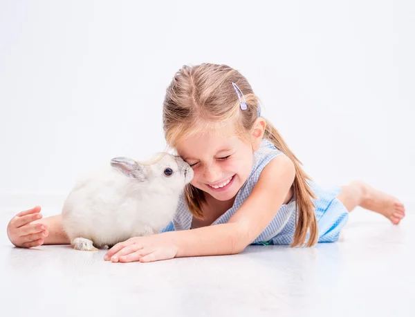 Süßes lächelndes Mädchen mit einem weißen Kaninchen — Stockfoto