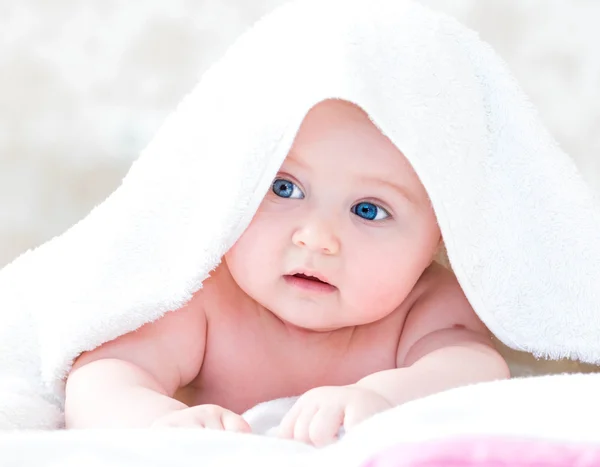 Ребенок под белым одеялом — стоковое фото