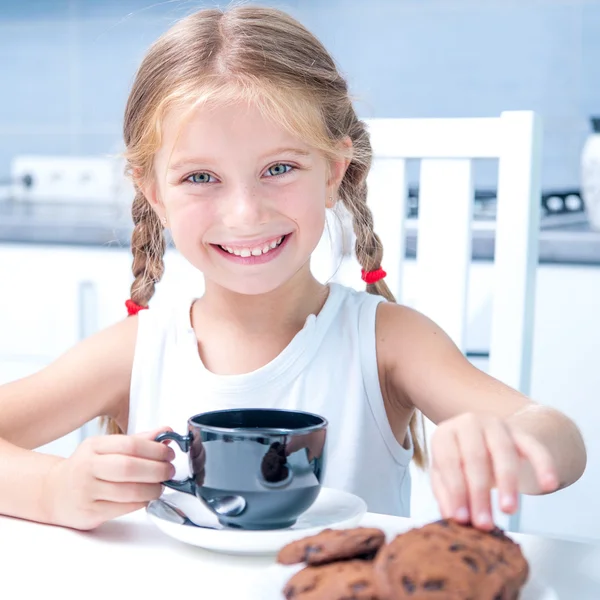 Cute dziewczynka picie herbaty z ciasteczkami — Zdjęcie stockowe