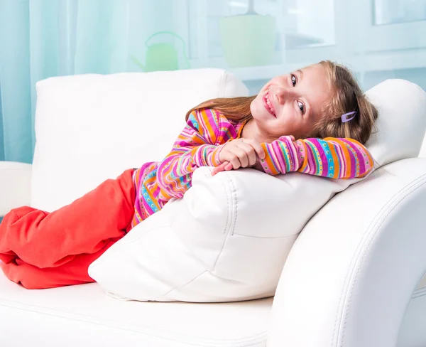 Little girl on a white sofa — Stock Photo, Image