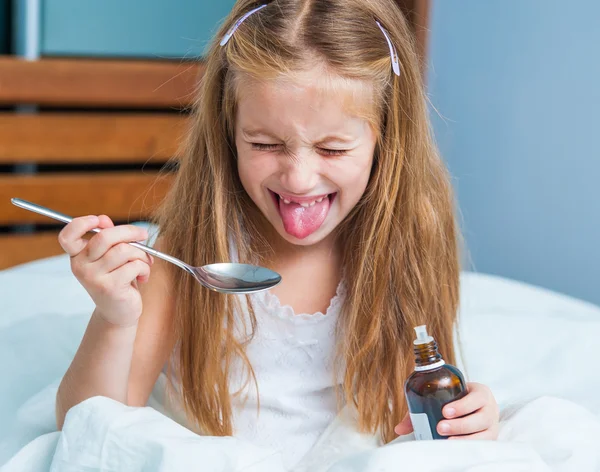 Menina segurando um frasco de xarope de tosse — Fotografia de Stock