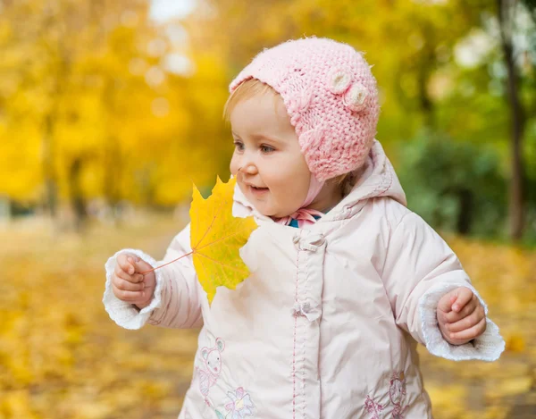 Liten flicka bland höstlöv — Stockfoto