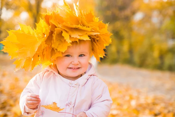 Cute little girl among maple leaves — Stock Photo, Image