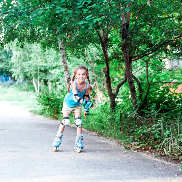 Fille Enfant Souriante Dans Un Casque En Rollers De Protection Dans Le Parc