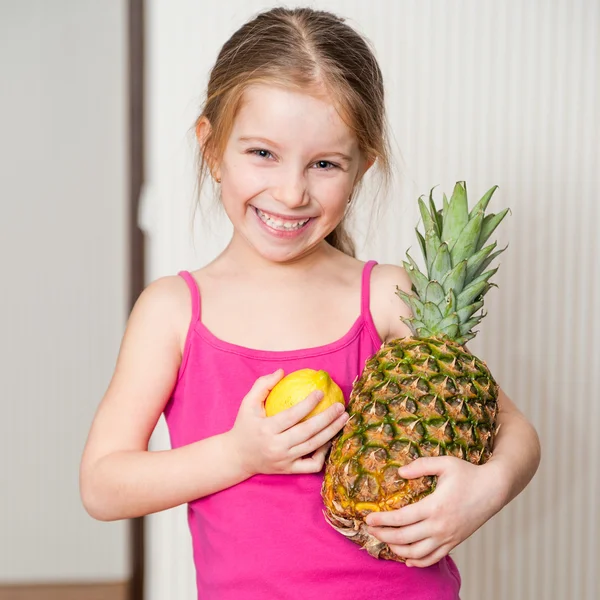 Kleines Mädchen mit Ananas und Zitrone — Stockfoto