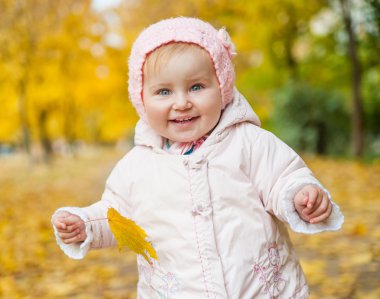 sonbahar yaprakları arasında küçük bir kız