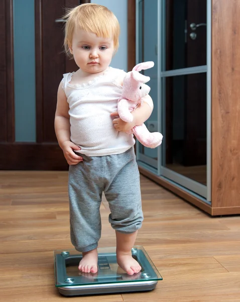 Cute baby on home scales — Stock Photo, Image