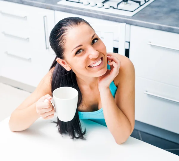 Mooi meisje het drinken van thee in de keuken — Stockfoto