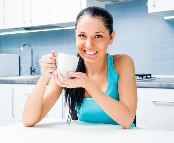 Mooi meisje het drinken van thee in de keuken — Stockfoto