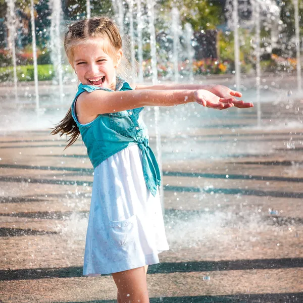 Niña en salpicaduras una fuente —  Fotos de Stock