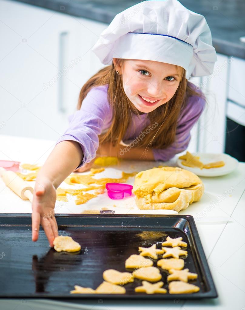 little girl puts on baking cookies