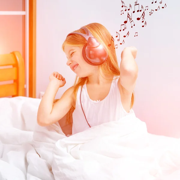 Liten jente som hører på musikk – stockfoto