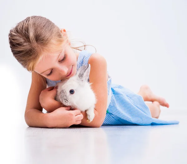 Carino bambina un bianco coniglio — Foto Stock