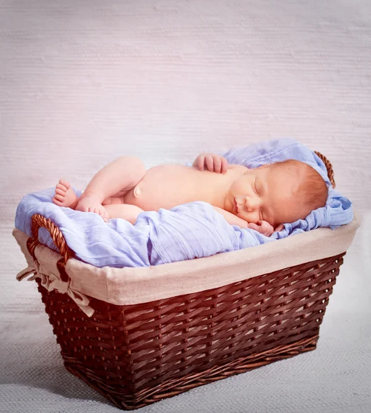Menino recém-nascido dormindo em uma cesta — Fotografia de Stock