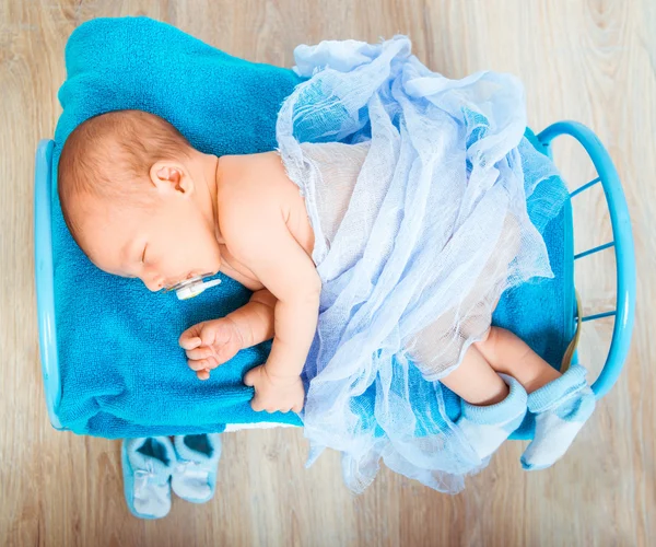 Bebê recém-nascido dorme em uma pequena cama — Fotografia de Stock