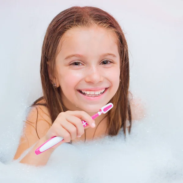 Little girl brushing teeth in bath — Stock Photo, Image