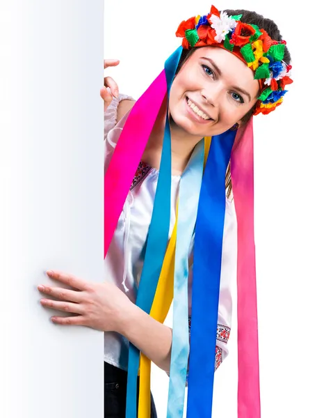 Meisje in Oekraïense kostuum achter wit bord — Stockfoto
