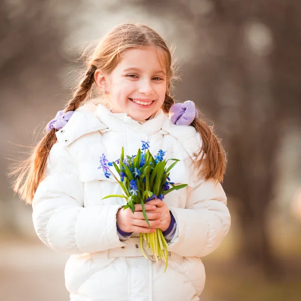 Menina com um snowdrops — Fotografia de Stock