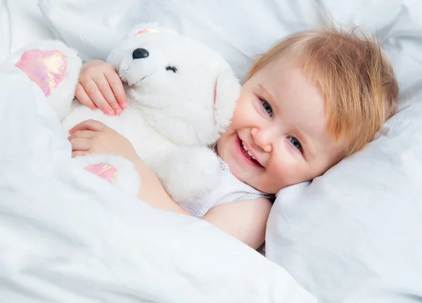 Ребенок, лежащий в белой кровати — стоковое фото