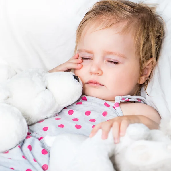 Baby with a toys in white bed — Stock Photo, Image