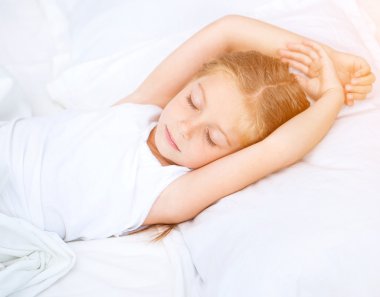 Beyaz yatakta uyuyan kız