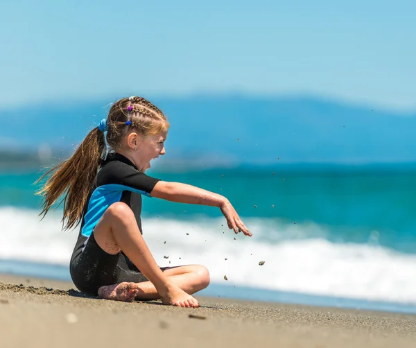 Flicka sitter på stranden — Stockfoto