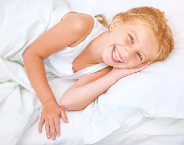 Flickan vaknade i sängen — Stockfoto