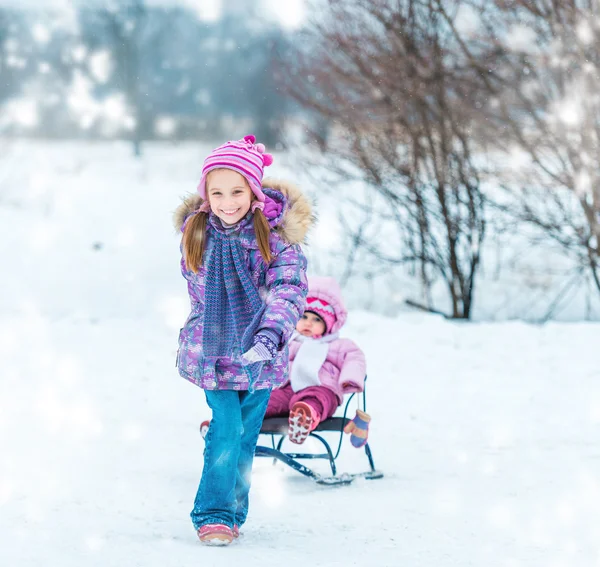 Girl sledding his sister — Stock Photo, Image