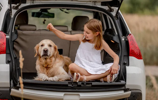 Nastolatka dziewczyna z golden retriever pies w samochód bagażnik — Zdjęcie stockowe