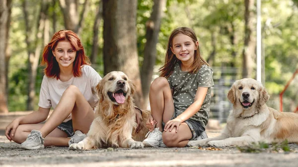 Meninas com cães golden retriever — Fotografia de Stock