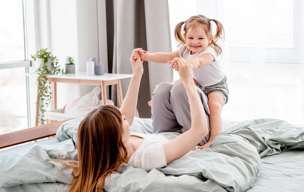 Mor med daughetr i sängen — Stockfoto