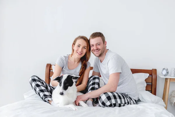 Gezin met hond in bed — Stockfoto