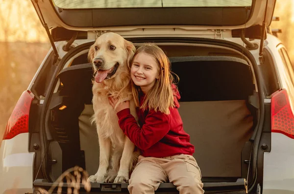 Dziewczyna z psem golden retriever w samochodzie — Zdjęcie stockowe