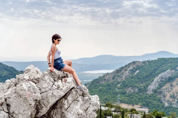 Mujer joven sobre un fondo de montañas — Foto de Stock