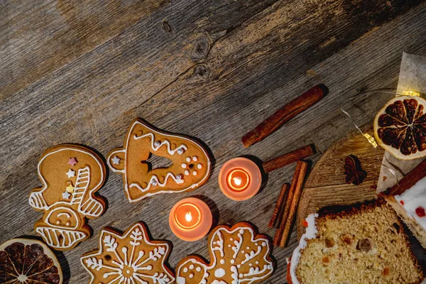 Figuras festivas de pan de jengibre cerca de velas y caramelos —  Fotos de Stock