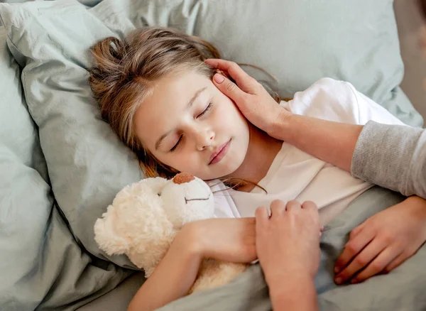 Menina com ursinho de pelúcia brinquedo na cama — Fotografia de Stock