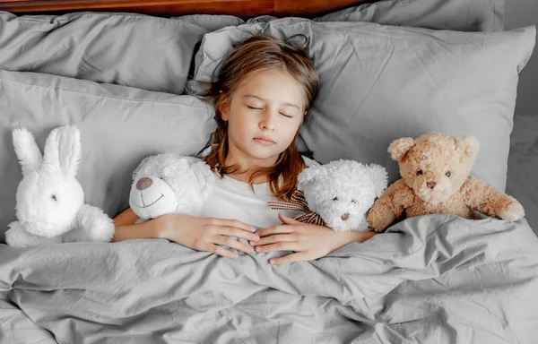 Child girl with teddy bear toy in the bed — Stock Photo, Image