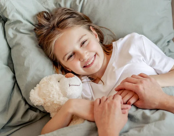 Kind meisje met teddybeer speelgoed in het bed — Stockfoto