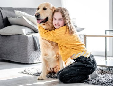 Golden retriever köpeği olan küçük bir kız.