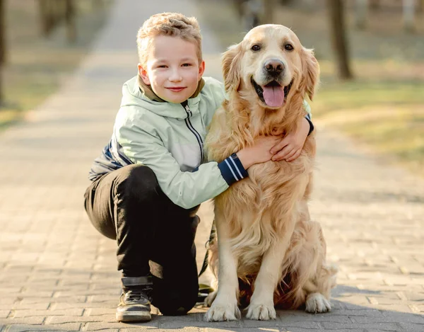 Preteen garçon avec golden retriever chien — Photo