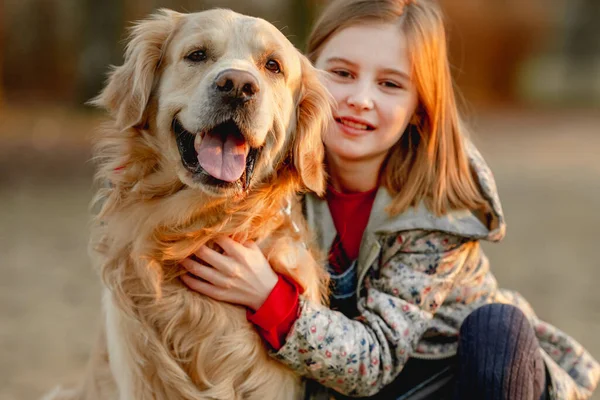 Девочка-подросток с золотой собакой — стоковое фото