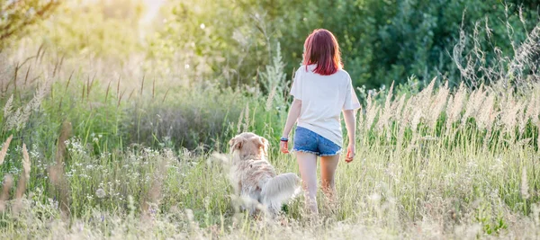 Menina adolescente com cão golden retriever — Fotografia de Stock