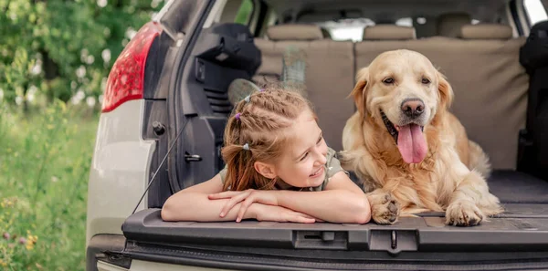 Nastolatka z psem golden retriever w samochodzie — Zdjęcie stockowe