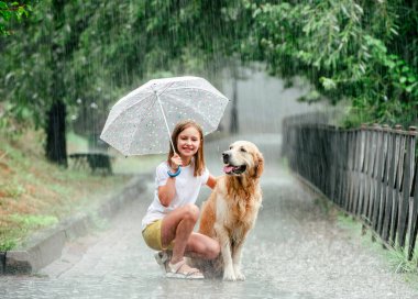 Yağmurlu günlerde Golden Retriever köpeği olan kız